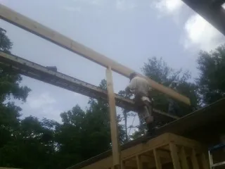 Carpenter setting a ridge beam over a new addition frame — Ice Dam Removal by Roofing Brothers in Waynetown