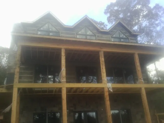 Dormers and porch framing on a large log home under construction — Roof Coating work by our crew in Waynetown