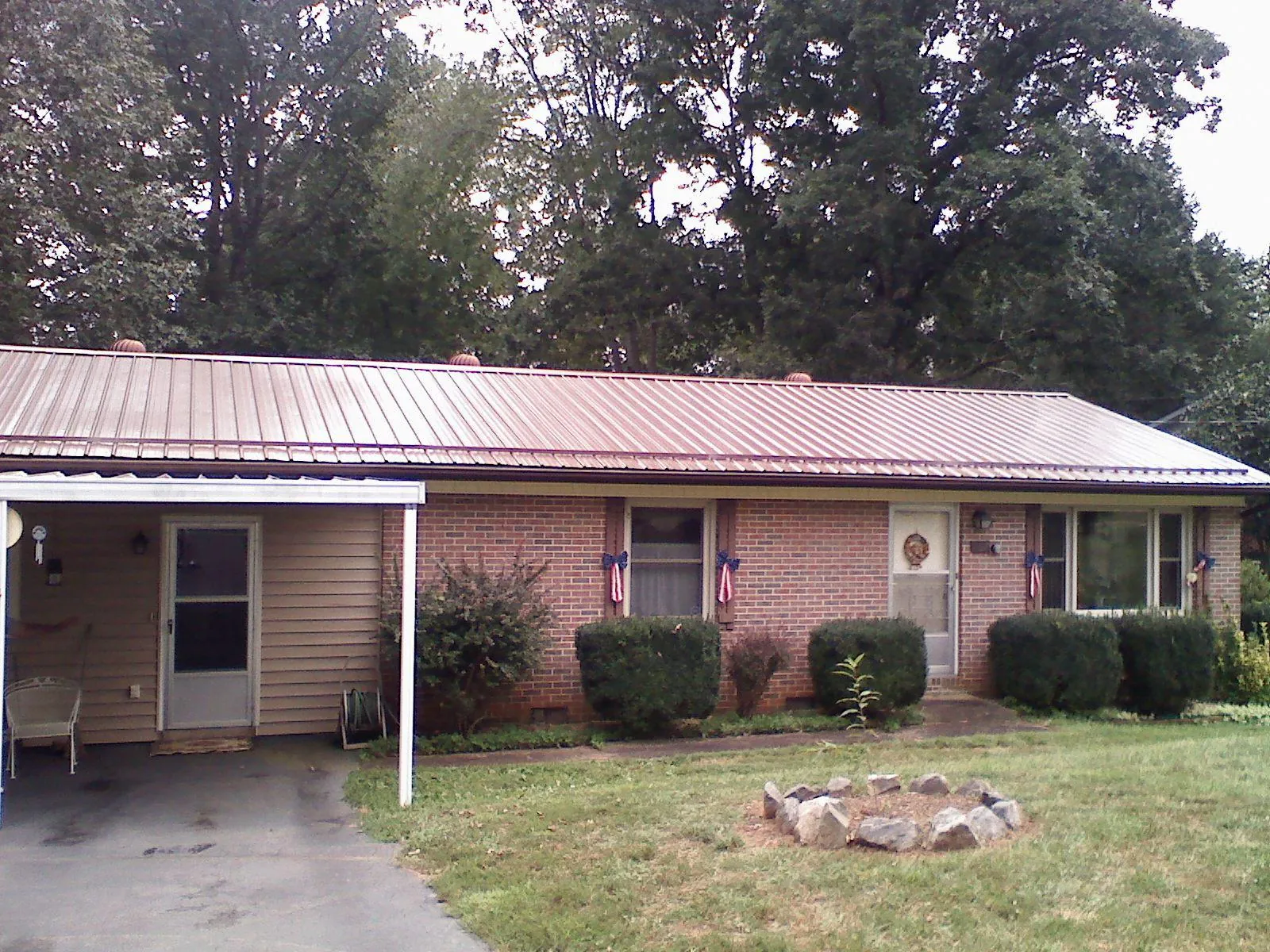 Bronze metal roof and carport on a brick ranch home — Roof Repair work by our crew in Waynetown